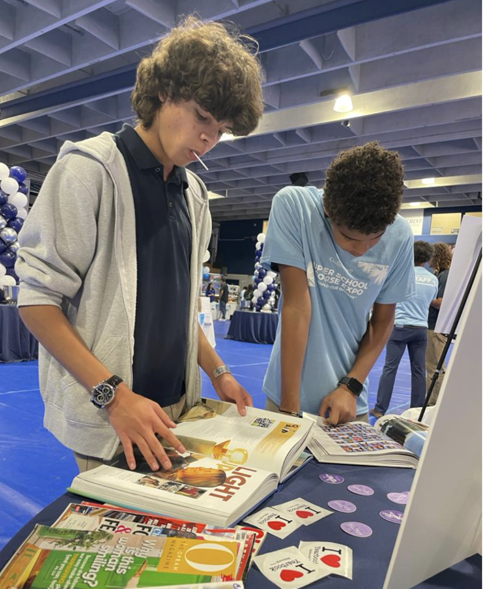 Two students flip through past editions of the yearbook at the multimedia table. The first annual Course Expo was an opportunity for students to explore all the courses offered to them. With the wide variety available, students had an entire period to explore their options.